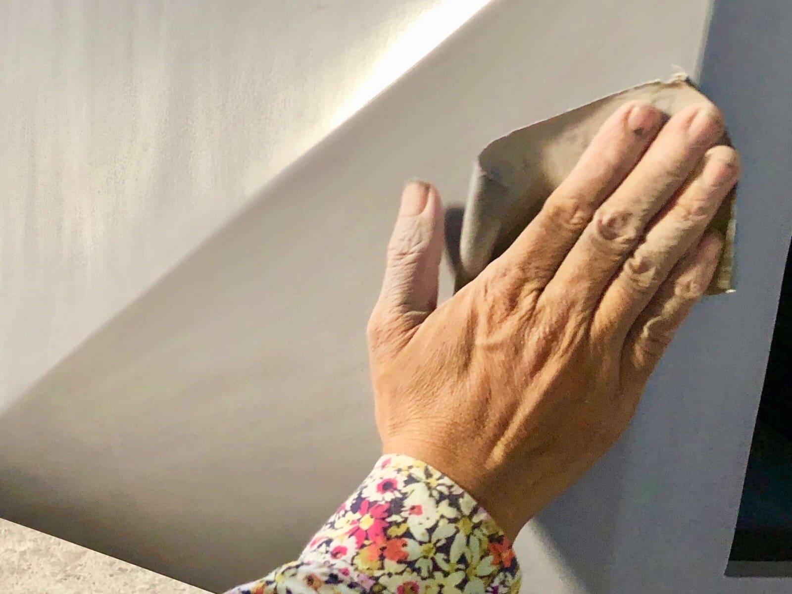 Sanding between each layer of the lacquer paint.