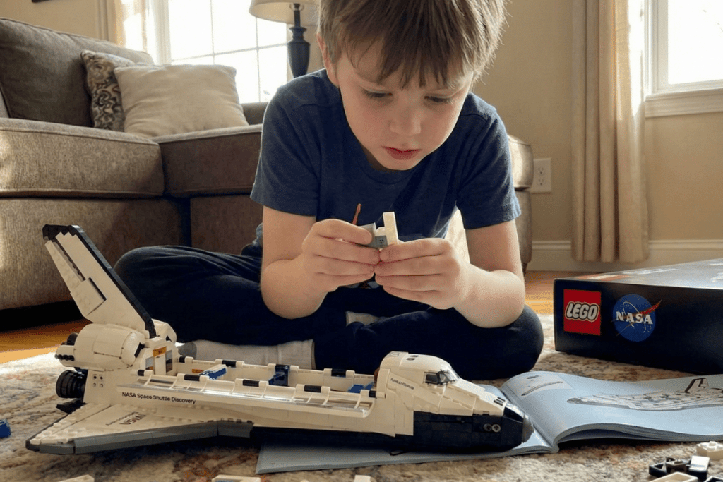 Small Boy playing with the NASA and LEGO toy set.